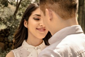 Close-up of a smiling couple sharing a tender moment outdoors.
