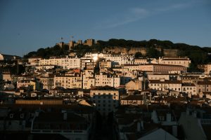 A stunning sunset view of São Jorge Castle in Lisbon, Portugal, highlighting medieval architecture.