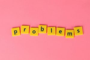 Yellow letter tiles spelling 'problems' on a contrasting pink background. Perfect for creative design projects.