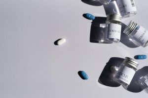 Flat lay of medicine bottles and pills on a white background, perfect for healthcare themes.