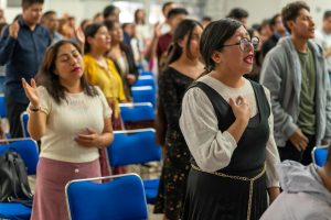 Group of people praying during a religious service in Ciudad de México, CDMX, México.