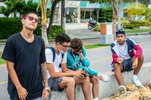 A group of young men socializing on a street in Cartagena, capturing urban vibes.