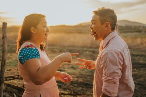 Two adults enjoying a playful moment outdoors at sunset, radiating joy and connection.