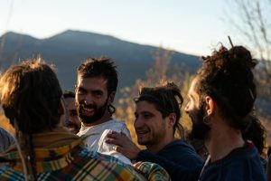 A group of friends laughing and bonding outdoors during a sunny day.