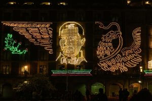 Colorful LED display of patriotic symbols and figures in Mexico City's historic center.