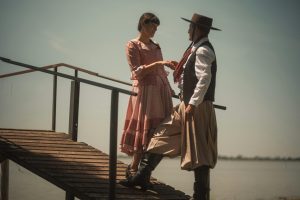 Gaucho couple in traditional attire dancing on a wooden pier in Chascomús, Argentina.