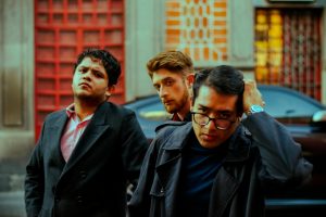 A vibrant urban portrait of three young men in stylish attire outdoors.
