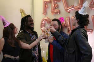 Friends celebrating New Year with party hats and a toast, full of joy and happiness.