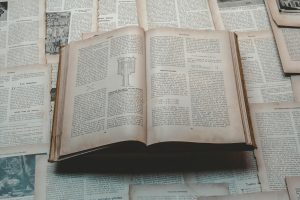 Explore a classic open book surrounded by vintage papers, perfect for historical and educational themes.