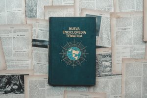 A classic encyclopedia book surrounded by historical text pages, evoking a sense of knowledge and history.
