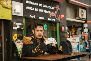 A man in a naval uniform poses at an outdoor cafe in Buenos Aires, Argentina.