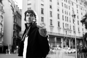 A black and white portrait of a man in historic costume on a street in Buenos Aires.