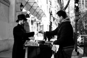 Black and white photo of a street vendor and customer exchanging goods in Buenos Aires.