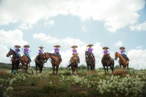 A group of charros on horseback in a rural setting in Hidalgo, Mexico, showcasing traditional attire.
