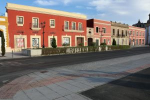 Colorful historic buildings line an empty street in El Puerto de Santa María, Spain.