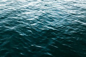 A dynamic capture of ocean water showing vivid textures and rich blue hues under daylight.