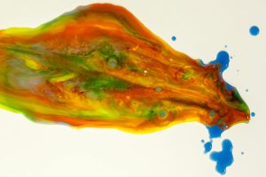Dynamic liquid art with vivid colors and fluid shapes creating an abstract, vibrant pattern.