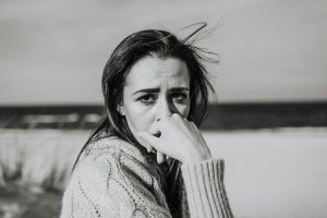 A monochrome portrait of a woman with pensive expression at the beach.