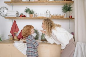 Warm moment between mother and son in a cozy kitchen filled with homey elements.