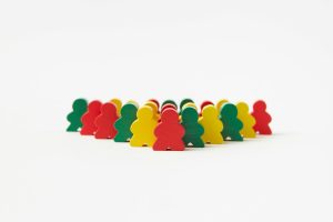 Vibrant wooden toy figures arranged in rows against a plain background, emphasizing organization and creativity.