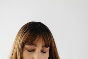 Close-up portrait of a woman with closed eyes and brunette hair, exuding calmness and serenity.