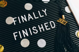 Close-up of a letter board with 'Finally Finished' text and 2021 graduation tassel.