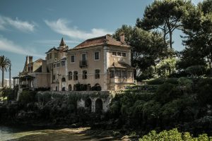 Casa de Santa Maria in Cascais by the sea, surrounded by lush greenery.