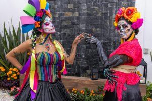 Colorful Día de los Muertos celebration with face paint and traditional Mexican costumes in CDMX.