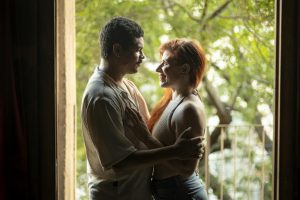 A loving couple sharing a tender moment by a doorway with natural light flowing in. Captured in Buenos Aires.