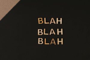 Close-up of wooden letters spelling 'blah', arranged on a black background, offering a conceptual design with copy space.