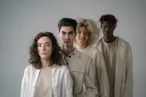 A stylish group of diverse adults posing together in a studio.