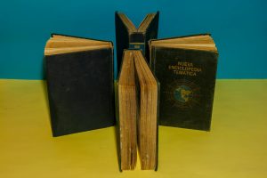 A collection of vintage encyclopedia books arranged creatively on a vibrant blue and yellow background.