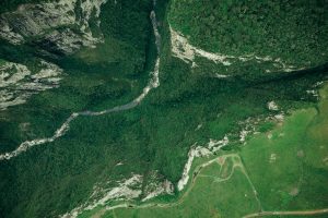Breathtaking aerial shot of lush canyon landscape in Cambará do Sul, Brazil, showcasing dense forests and rugged rock formations.
