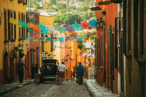 Vibrant street scene in San Miguel de Allende, Mexico with colorful papel picado decorations.