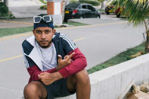 Casual urban portrait of a young man sitting on a street in Cartagena, Colombia.