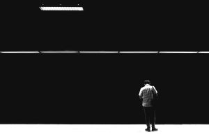 Black and white photo of a man standing alone on a subway platform in Istanbul.