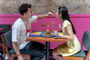 A young couple sharing a meal at a colorful restaurant in Mexico City, CDMX.