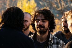 A joyful group of adults interacting in a sunny outdoor setting, showcasing friendship and happiness.