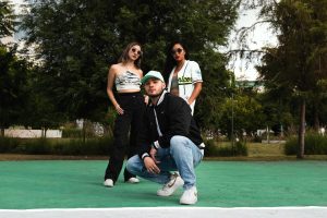 Young adults in stylish outfits pose confidently in a vibrant park setting.