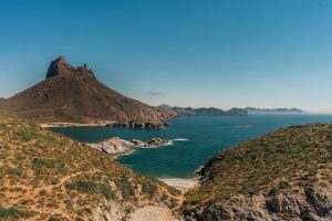 Breathtaking view of rocky hills and serene coastline in Mexico under a clear blue sky.