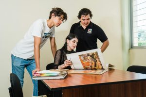 Students collaborating on art analysis at a Culiacán university. Engaged in discussion over art books.