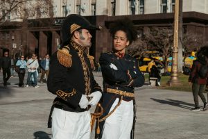 Actors in military uniforms reenacting historical events on a sunny day in Buenos Aires.