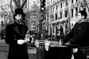 A man in formal attire buys food from a street vendor in Buenos Aires.