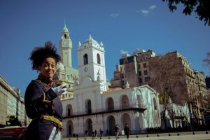 A smiling guard in uniform stands in front of the historic Cabildo building in Buenos Aires, Argentina.