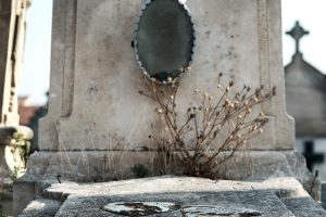 A close-up of a weathered tombstone in Arles Cemetery, capturing the essence of history and decay.