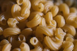 Detailed macro shot of uncooked fusilli pasta, showcasing texture and spiral shapes.
