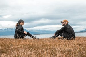 Romantic couple sitting outdoors in Ushuaia, Argentina with breathtaking mountain view.