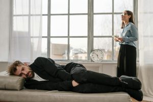 A man lying on a couch during a counseling session with a female therapist.