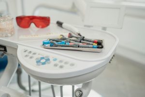 Assortment of dental tools and devices on a clinic table.