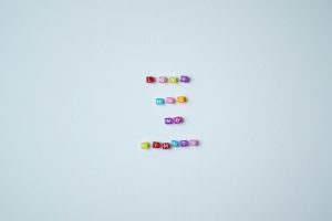 Vibrant bead letters spelling 'Love Has No Limits' on a gray background promoting inclusivity.
